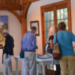 Guests viewing Max Moran's art exhibit in the barn at Jedediah Hawkins Inn