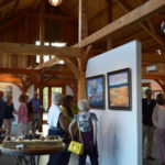 Guests viewing Max Moran's art exhibit in the barn at Jedediah Hawkins Inn