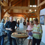 Guests viewing Max Moran's art exhibit in the barn at Jedediah Hawkins Inn